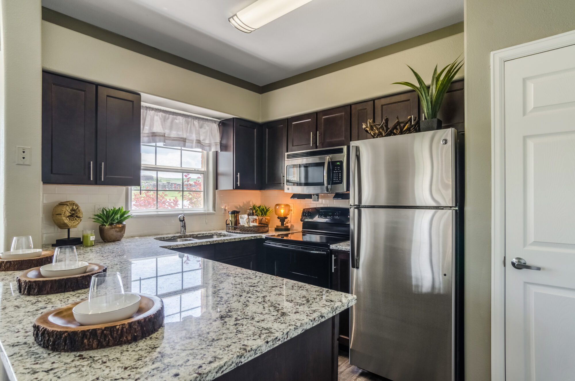 Kitchen with stainless steel appliances, granite counters, and tile backsplash