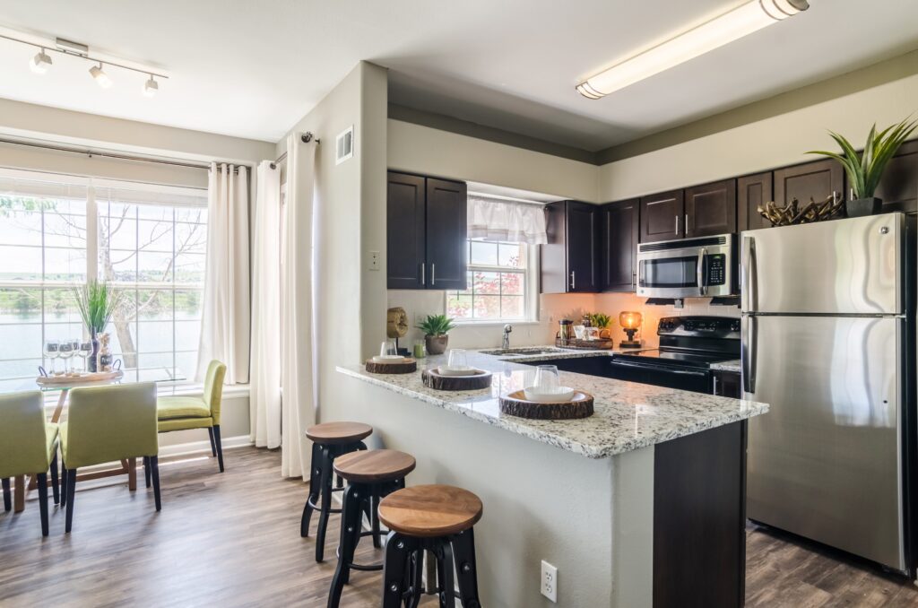Kitchen with granite counters, stainless steel appliances, and tile backsplash