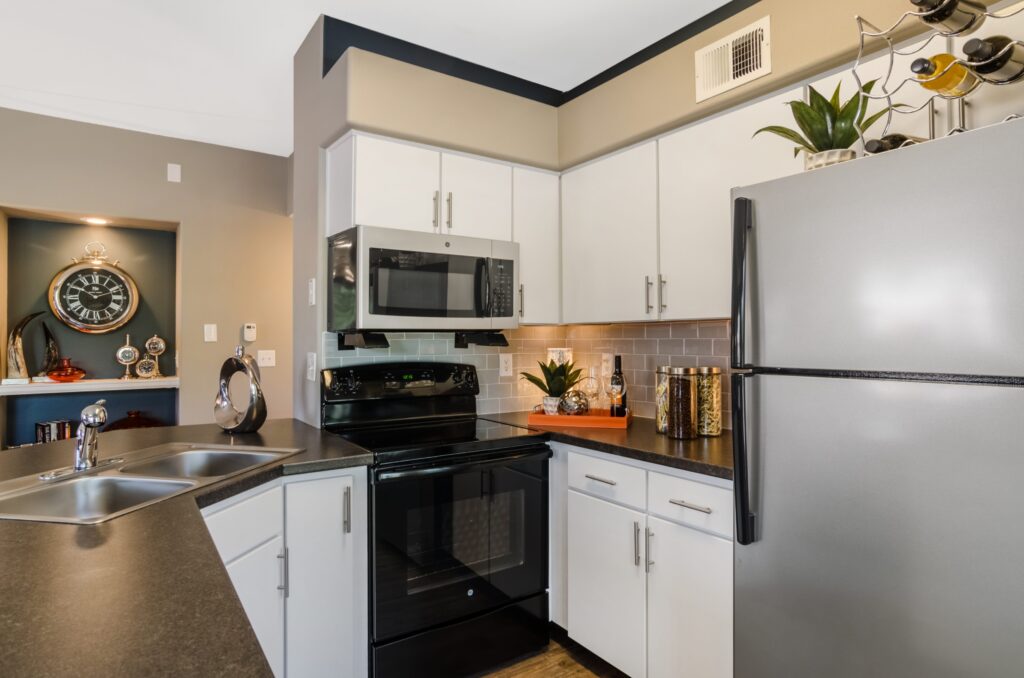 Kitchen with granite counters, stainless steel appliances, and tile backsplash