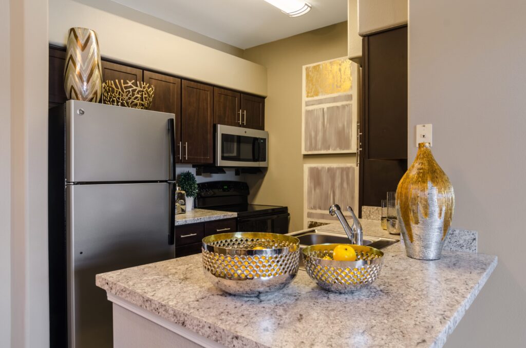 Kitchen with granite counters, stainless steel appliances, and tile backsplash